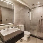 Private bathroom with walk-in shower and illuminated mirror