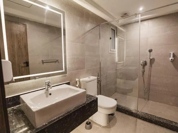 Private bathroom with walk-in shower and illuminated mirror